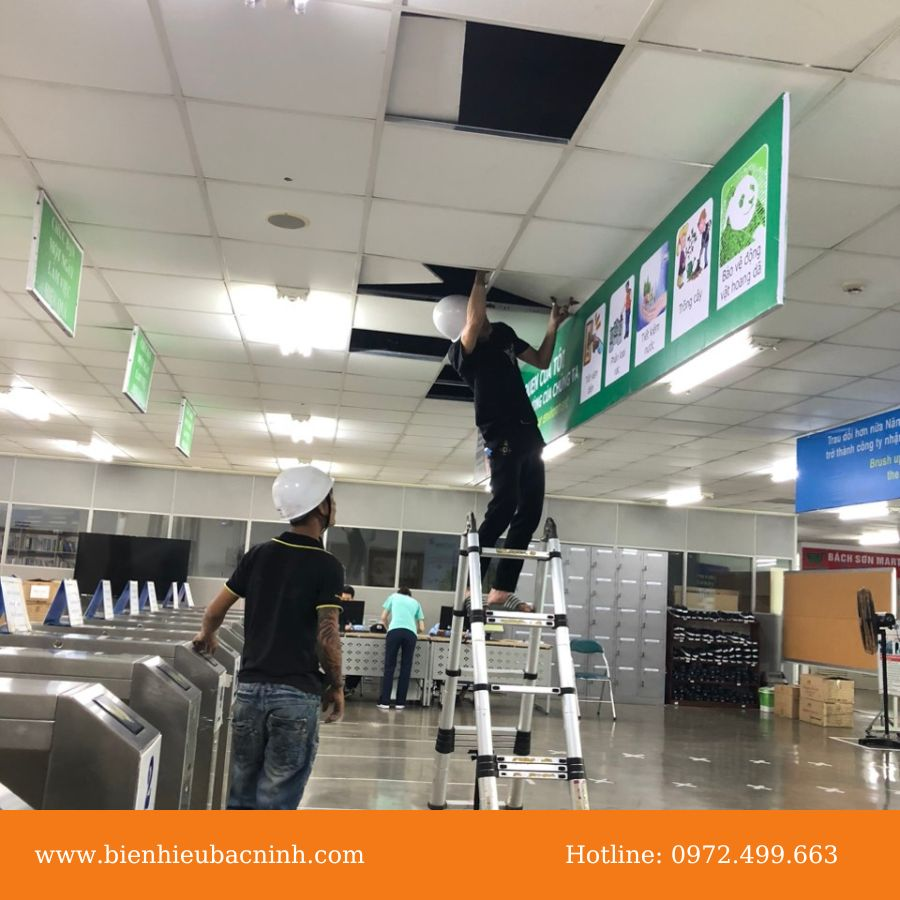 Nhân viên Q Pro đang thực hiện dịch vụ lắp đặt biển bạt cho khách hàng